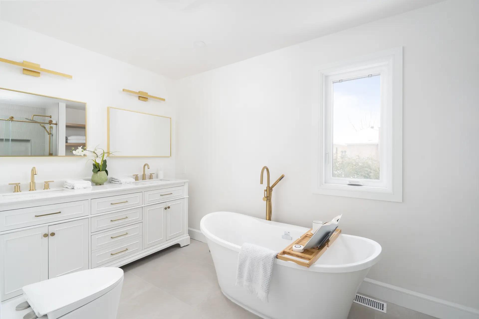 Modern and bright bathroom with a freestanding bathtub and brass finishes