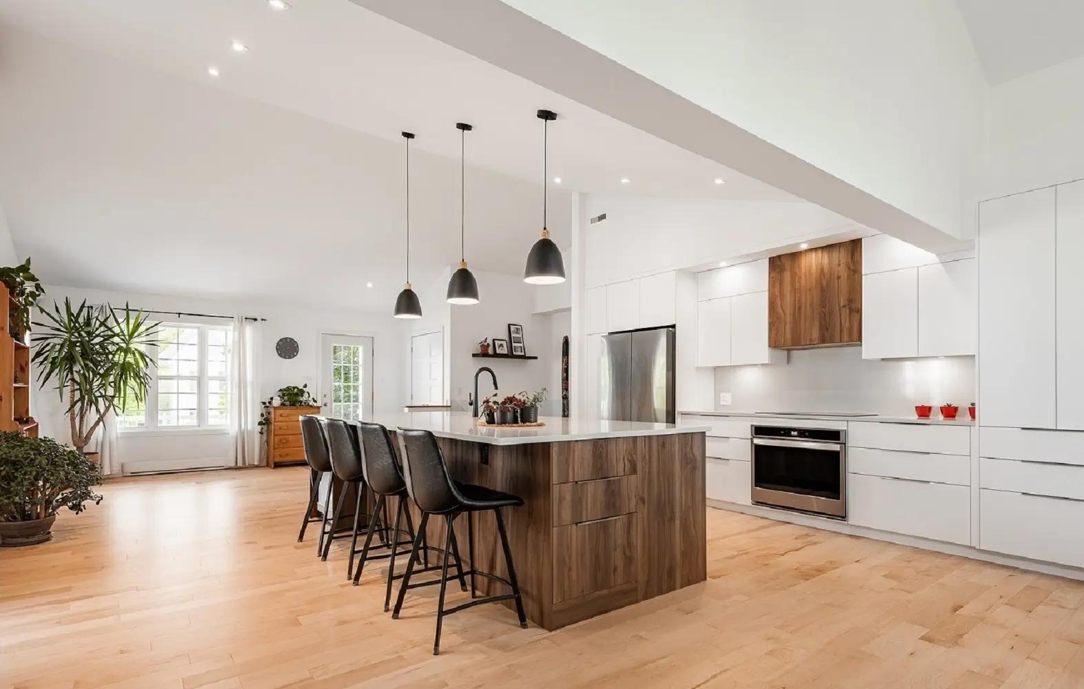 Scandinavian-looking kitchen with a contemporary twist. The pairing of light wood, white, and black makes for a cozy yet sleek setting. The kitchen island is perfect for meals with family or friends.