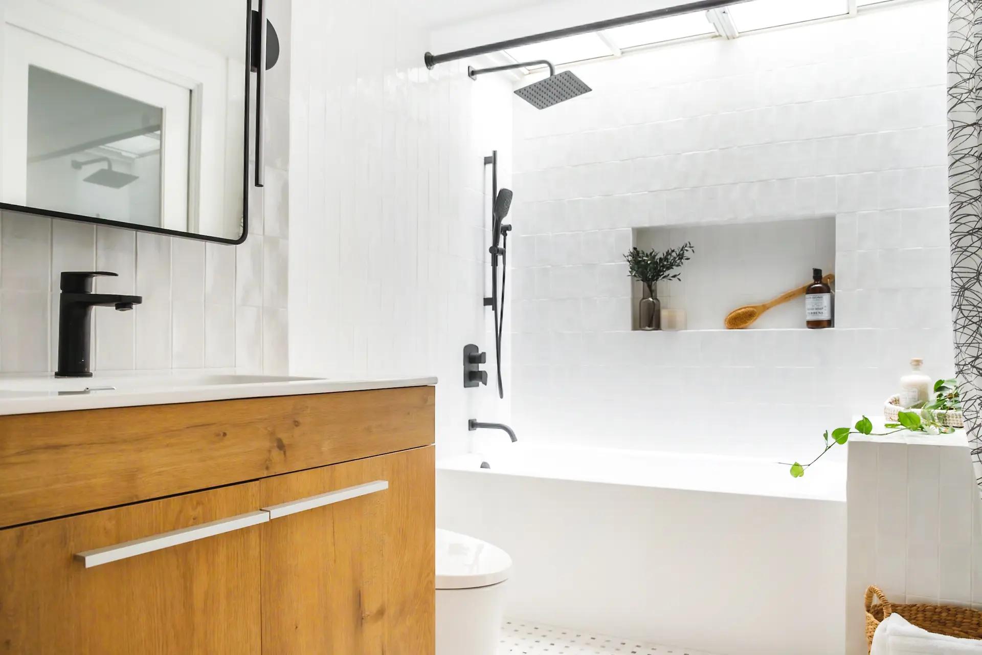 Bright bathroom with a white bathtub, a shower equipped with a rain showerhead, and a wooden under-sink vanity