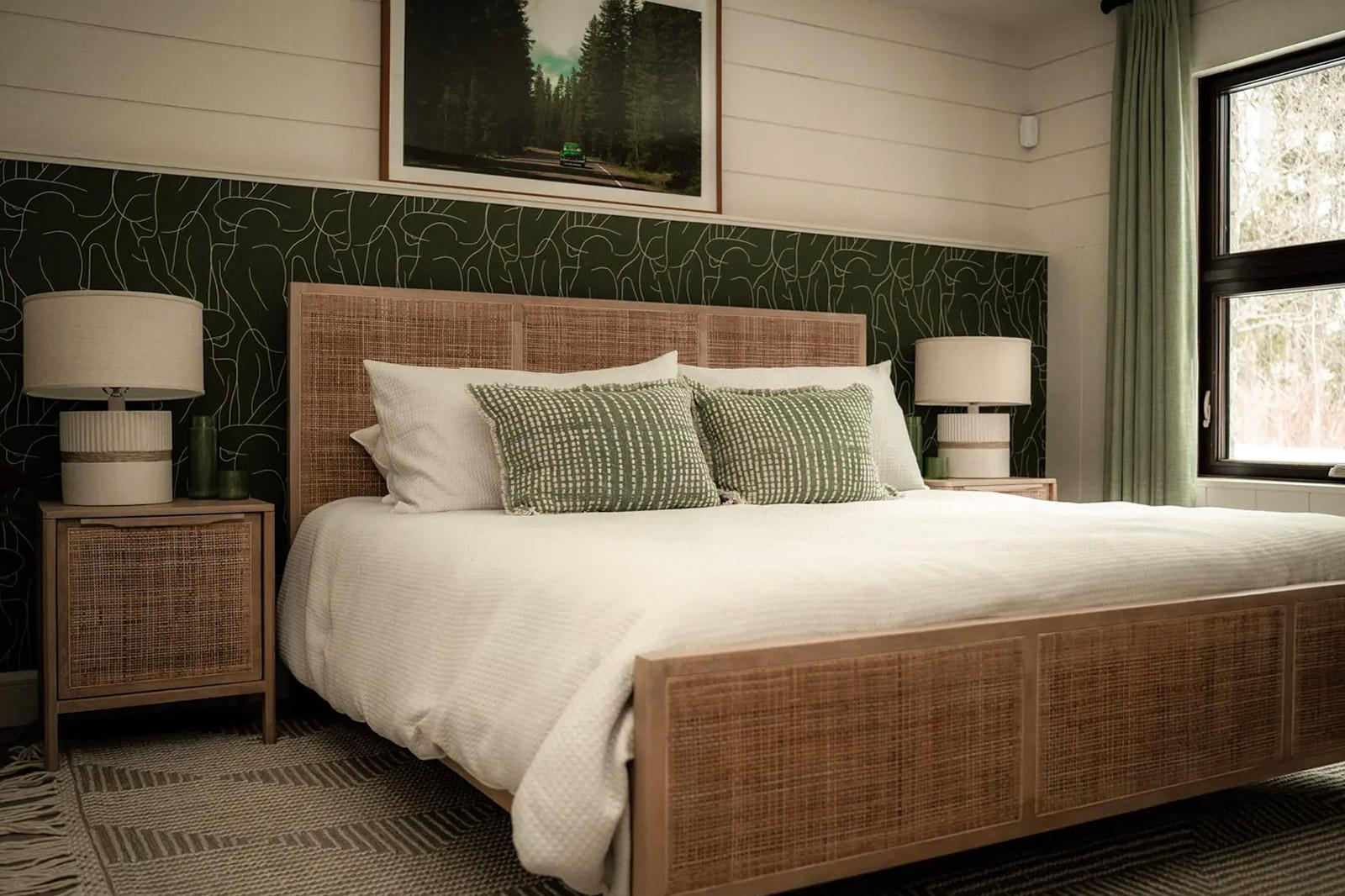 Cozy bedroom with women wood bed. green accent wall, and natural decor.