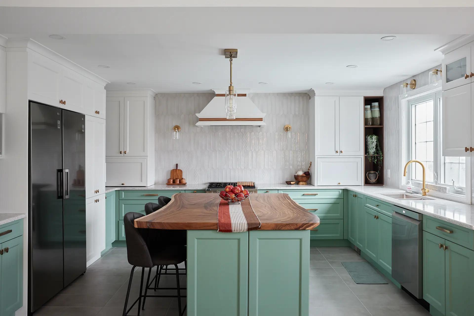 Transitional-style kitchen in Montreal, featuring a natural veneer center island with clean lines. Mint-green cabinetry and copper handles add a fresh, elegant touch to the space. The textured backsplash and neutral ceramic floor create an interesting contrast.